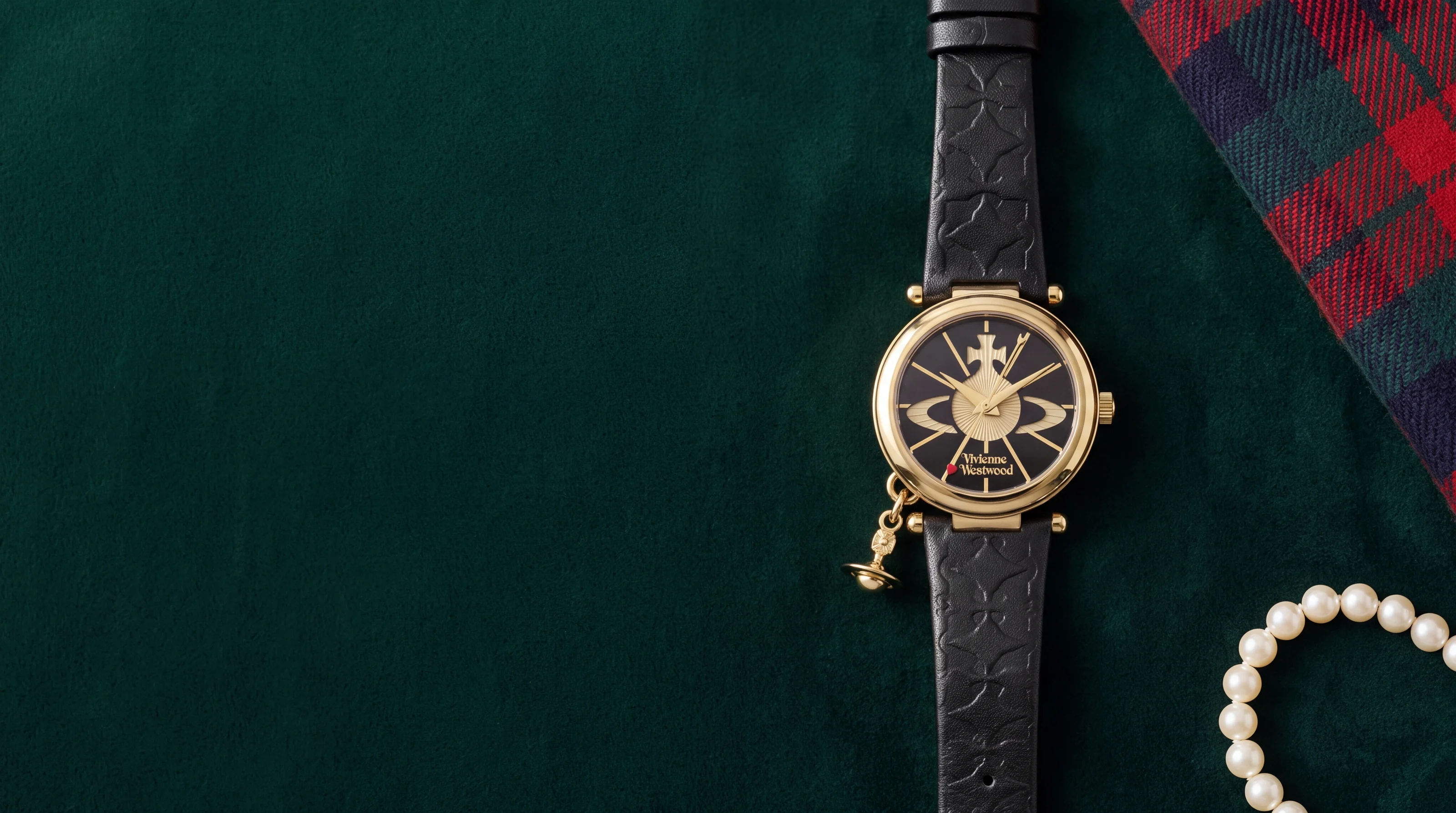 Montre Vivienne Westwood Orb VV006BKGD dorée, cadran noir à grand orbe et breloque, sur velours vert bouteille