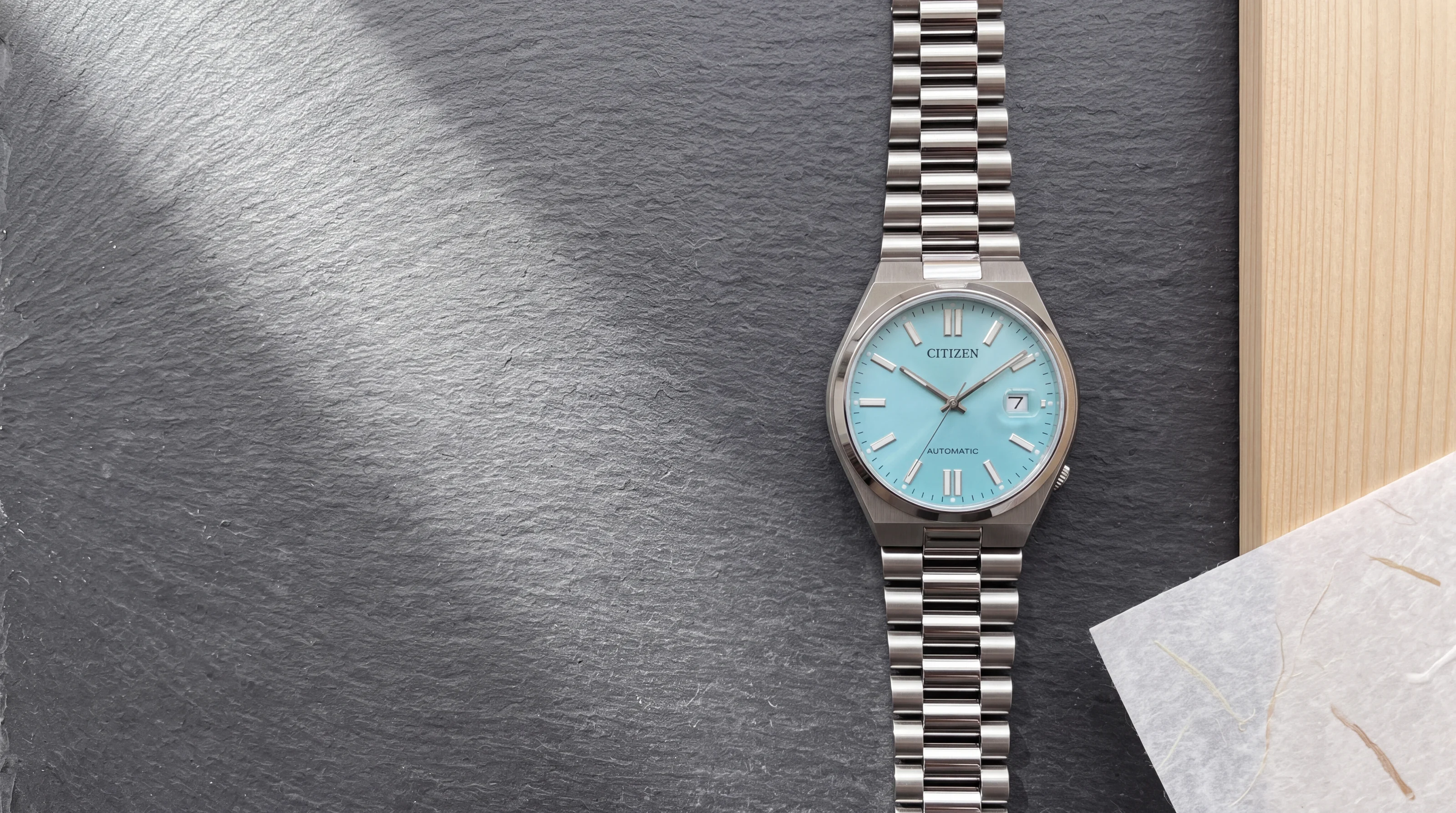 Montre Citizen Tsuyosa NJ0151-88M automatique, cadran bleu glacier, bracelet acier intégré, sur ardoise