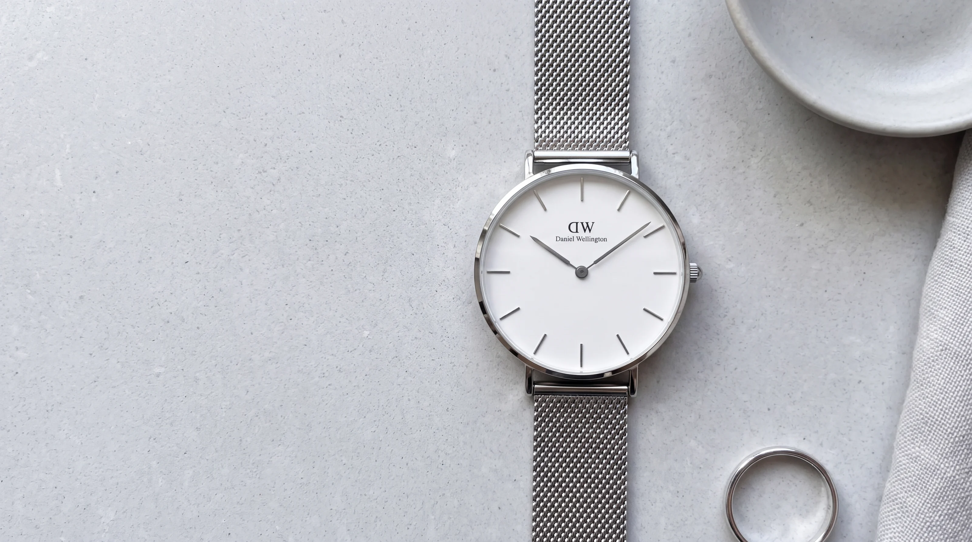 Montre Daniel Wellington Petite Sterling 32 mm en acier argenté, cadran blanc, sur une pierre grise claire