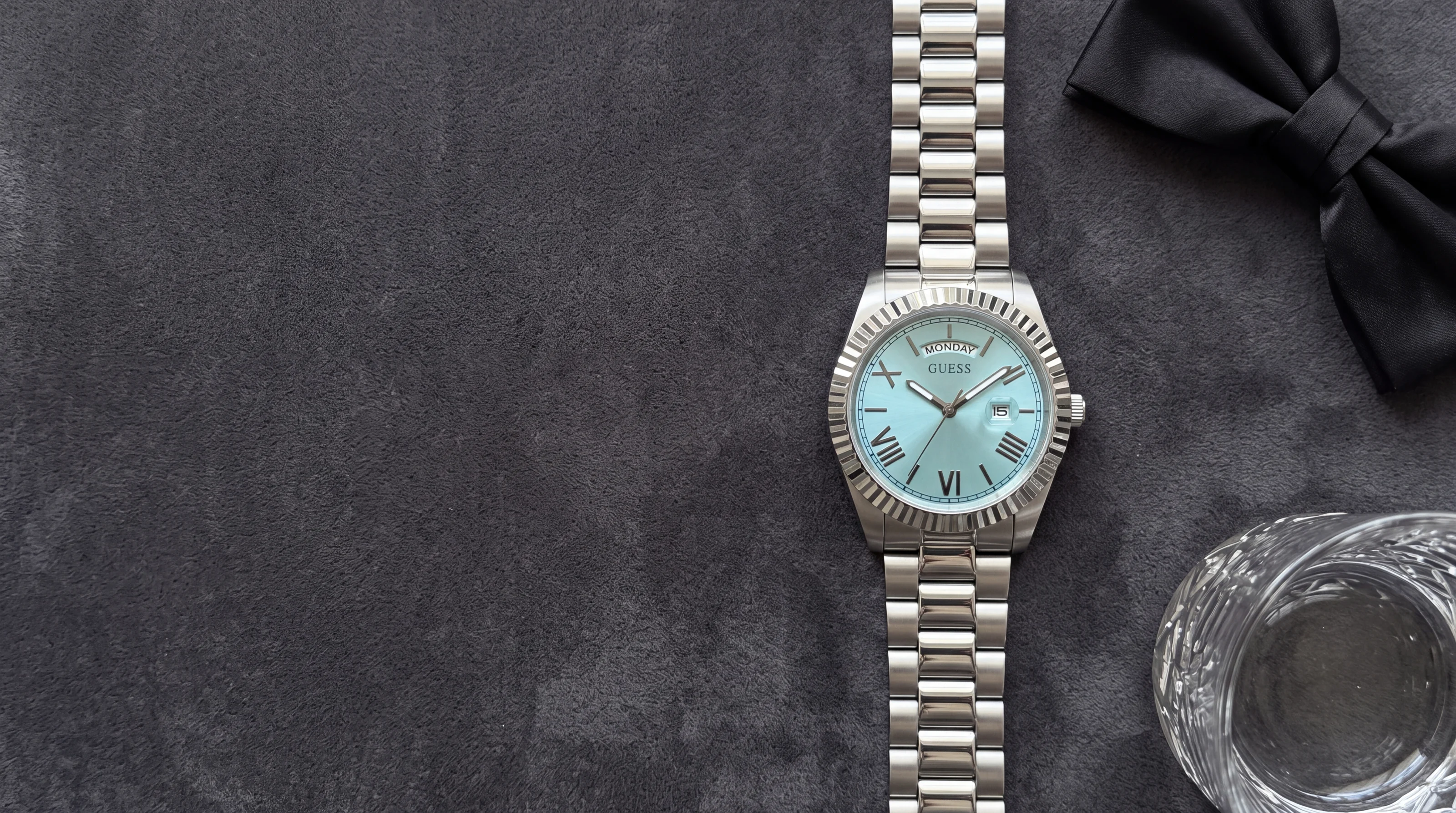 GUESS Connoisseur GW0265G11 steel men's watch with turquoise dial and fluted bezel on charcoal velvet