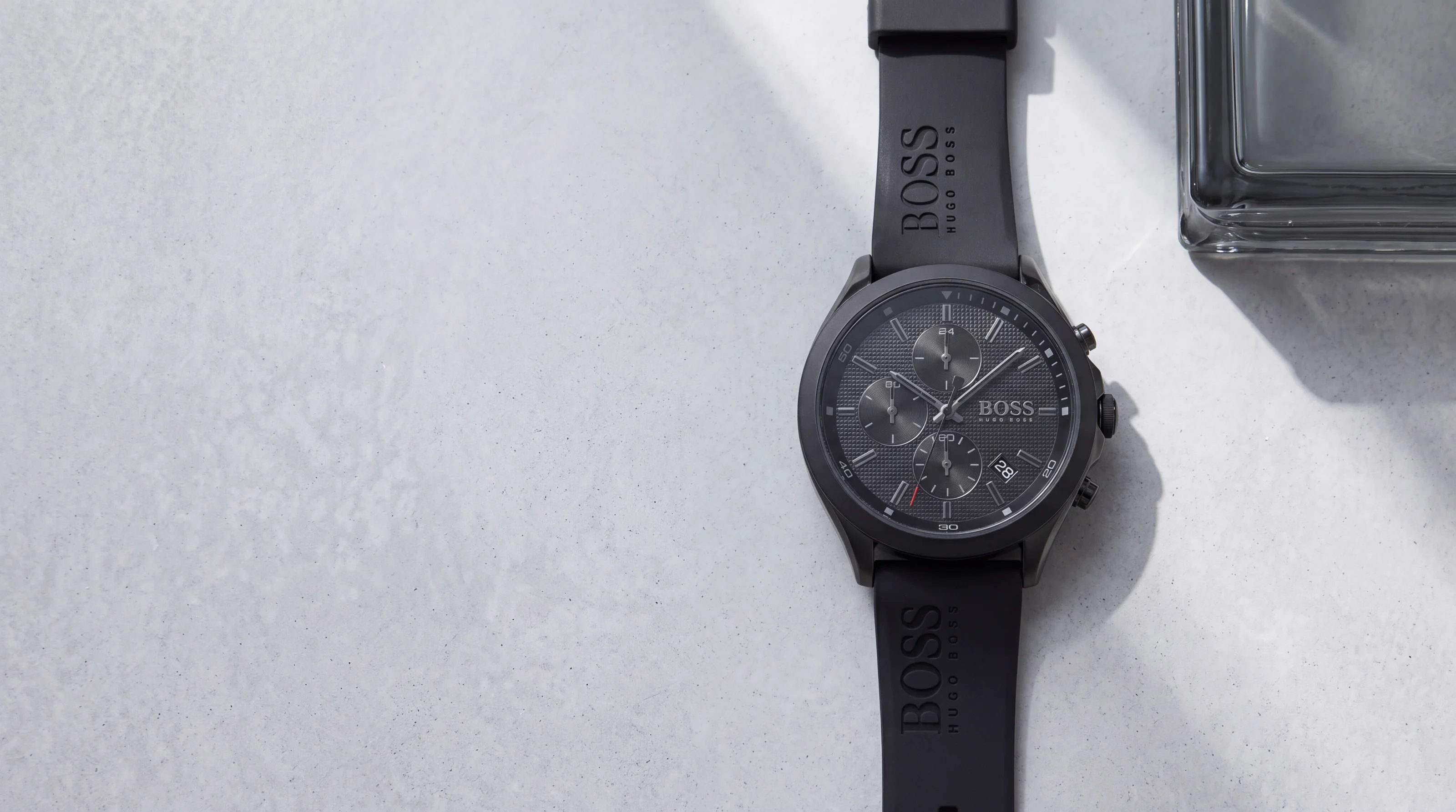 HUGO BOSS Velocity 1513720 all-black men's chronograph with silicone strap on pale grey polished concrete